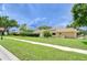 A well-maintained lawn surrounds this single-story home with a manicured landscape at 17302 Stetson Ln, Odessa, FL 33556