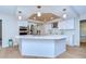 Spacious kitchen featuring an island, wood plank ceiling, stainless steel appliances, and bright white cabinetry at 17302 Stetson Ln, Odessa, FL 33556