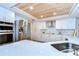Bright kitchen features stainless steel appliances, stylish mosaic backsplash, and a unique wood plank ceiling at 17302 Stetson Ln, Odessa, FL 33556