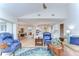 Open-concept living room with light wood floors, blue accent chairs, and views to dining area and kitchen at 17302 Stetson Ln, Odessa, FL 33556