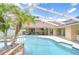 Inviting pool with spa and screen enclosure surrounded by lush landscaping at 17302 Stetson Ln, Odessa, FL 33556
