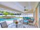 An outside covered patio features comfortable seating and a view of the inviting pool at 17302 Stetson Ln, Odessa, FL 33556