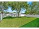 Green backyard featuring a white privacy fence and mature trees at 1734 Mapleleaf Blvd, Oldsmar, FL 34677