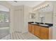 Bathroom featuring double sink vanity and access to another room, offering spacious design at 1734 Mapleleaf Blvd, Oldsmar, FL 34677