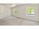 Carpeted bedroom features a ceiling fan and sun-filled double windows at 1734 Mapleleaf Blvd, Oldsmar, FL 34677