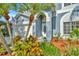 Inviting front entrance with a decorative door, lush plants, and mulched flower beds at 1734 Mapleleaf Blvd, Oldsmar, FL 34677