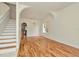 Open-concept living space with hardwood flooring, staircase, and an arched doorway to the kitchen at 1734 Mapleleaf Blvd, Oldsmar, FL 34677