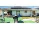 Backyard featuring outdoor seating, grill, solar panels and artificial turf at 1827 Peaceful Palm St, Ruskin, FL 33570