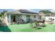 Backyard featuring outdoor seating, grill, solar panels and artificial turf at 1827 Peaceful Palm St, Ruskin, FL 33570