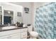 Full bathroom featuring a toilet, vanity with sink, framed mirror and a shower with blue curtain at 1827 Peaceful Palm St, Ruskin, FL 33570