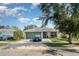 Charming single-story home featuring a well-maintained lawn and a paved driveway leading to an attached garage at 1827 Peaceful Palm St, Ruskin, FL 33570