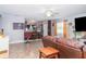 Open living room featuring tiled floors, ceiling fan, and a view of the kitchen with breakfast bar at 1827 Peaceful Palm St, Ruskin, FL 33570