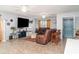 Cozy living room featuring tile floors, two ceiling fans and comfortable brown leather furniture at 1827 Peaceful Palm St, Ruskin, FL 33570