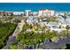 An aerial view of a property surrounded by tropical trees near a parking lot, close to the beach at 19109 2Nd St, Indian Shores, FL 33785