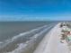 Picturesque aerial of beach with ocean waves and a nearby beach town at 19440 Gulf Blvd # 301, Indian Rocks Beach, FL 33785