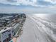 Sweeping aerial view of a beachfront community with a long stretch of sandy beach and ocean at 19440 Gulf Blvd # 301, Indian Rocks Beach, FL 33785