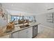 Kitchen island with stainless steel dishwasher opens to living and dining areas with ocean view at 19440 Gulf Blvd # 301, Indian Rocks Beach, FL 33785