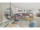 Living room features coastal decor, comfortable seating, and modern hanging chair at 19440 Gulf Blvd # 301, Indian Rocks Beach, FL 33785