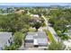 Aerial view of a single-Gathering home with screened-in patio near tropical landscaping and distant bay views at 2 S Treasure Dr, Tampa, FL 33609