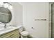 Bright bathroom featuring marble-look shower, toilet, and vanity with a lighted mirror at 2 S Treasure Dr, Tampa, FL 33609