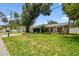 Charming single-story home featuring a well-manicured lawn and lush landscaping at 2 S Treasure Dr, Tampa, FL 33609