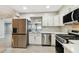 Bright kitchen with stainless steel appliances, white cabinets, and tile backsplash perfect for modern living at 2 S Treasure Dr, Tampa, FL 33609