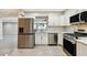 Updated kitchen showcases stainless steel appliances, white cabinets, and tile backsplash for a stylish cooking space at 2 S Treasure Dr, Tampa, FL 33609