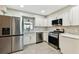 Well-lit kitchen with stainless steel appliances, white cabinets, and designer backsplash for an elegant touch at 2 S Treasure Dr, Tampa, FL 33609