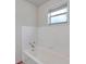 Clean bathroom featuring white tiling around the bathtub and a bright window at 2509 W Crawford St, Tampa, FL 33614