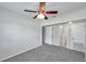 Bedroom featuring neutral carpet, ceiling fan, and access to an attached bathroom at 2509 W Crawford St, Tampa, FL 33614