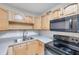 Close up of the kitchen with light wood cabinets and black appliances at 2509 W Crawford St, Tampa, FL 33614
