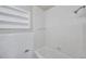 Bathroom shower with white tiled walls, built-in shelves, and adjustable shower head at 2509 W Crawford St, Tampa, FL 33614