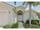 Inviting front entrance with an arched doorway, garden, and a well-maintained lawn at 2625 Brookville Dr, Valrico, FL 33596