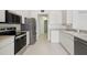 Modern kitchen with stainless steel appliances, including a refrigerator, range, and microwave, and bright white cabinets at 2625 Brookville Dr, Valrico, FL 33596
