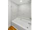 Bright bathroom with a bathtub featuring white marble-look tile and bench seating at 3062 Eastland Blvd # 308, Clearwater, FL 33761