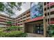 Building entrance showcases a modern glass facade and well-kept garden beds at 3062 Eastland Blvd # 308, Clearwater, FL 33761