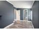 Bedroom with gray walls, white trim, wood-look floors, and an open doorway to another room at 3125 Beaver Creek Dr, Wesley Chapel, FL 33543