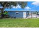 A charming blue home with a covered carport and lush green lawn at 3125 Beaver Creek Dr, Wesley Chapel, FL 33543