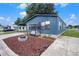 Charming blue home with a cozy porch swing and fire pit on a sunny day at 3125 Beaver Creek Dr, Wesley Chapel, FL 33543