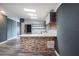Modern kitchen featuring a unique backsplash and granite countertops, skylights, and wood-look floors at 3125 Beaver Creek Dr, Wesley Chapel, FL 33543