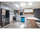 Stylish kitchen with stainless steel appliances, modern blue cabinets, and a stone-accented breakfast bar at 3125 Beaver Creek Dr, Wesley Chapel, FL 33543