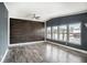 Bright living room featuring modern flooring, wood accent wall, and multiple windows at 3125 Beaver Creek Dr, Wesley Chapel, FL 33543