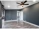 Open concept living room with wood-look floors, gray walls, and white trim leading to other areas of the home at 3125 Beaver Creek Dr, Wesley Chapel, FL 33543