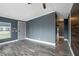 A view of the living room featuring wood-look floors, gray walls, white trim, and a gray front door at 3125 Beaver Creek Dr, Wesley Chapel, FL 33543