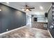 Modern living room leading into the kitchen with gray walls, skylights, and wood-look floors at 3125 Beaver Creek Dr, Wesley Chapel, FL 33543