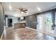 A modern living room leads into the kitchen through an open concept layout with wood-look floors at 3125 Beaver Creek Dr, Wesley Chapel, FL 33543