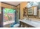 Bathroom with updated vanity, glass enclosed shower, and garden view at 3225 Rosery Ne Rd, Largo, FL 33771