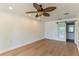 Spacious bedroom with hardwood floors, ceiling fan, and view of the bathroom through a barn door at 3225 Rosery Ne Rd, Largo, FL 33771