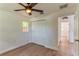 This bright bedroom has wood-look floors, a ceiling fan, a closet, and a door to the hallway at 3225 Rosery Ne Rd, Largo, FL 33771
