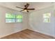 This bedroom is bright and has beautiful wood floors, neutral paint, a ceiling fan and two windows at 3225 Rosery Ne Rd, Largo, FL 33771